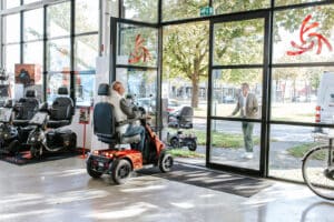 Een scootmobiel wordt de showroom uitgereden voor een proefrit.